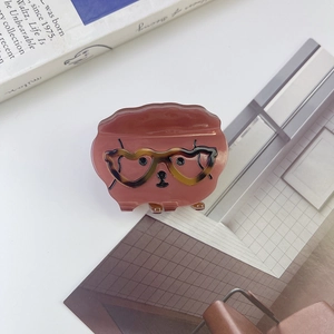 Détail macro d'une pince à cheveux chien avec lunettes cœur et texture acétate