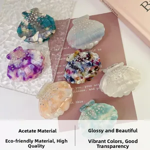 Detail showing various shell-shaped acetate hair claws with sparkling rhinestone accents