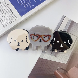 Trois pinces à cheveux chiot mignonnes en beige, gris et noir sur un fond esthétique