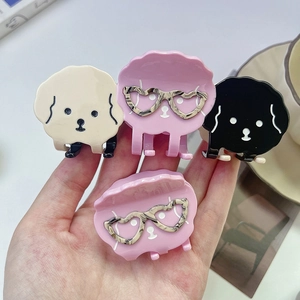 Détail de pinces à cheveux chiots mignonnes en beige rose et noir avec lunettes coeur