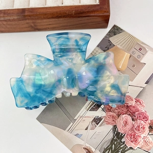 Détail d'une pince à cheveux à texture marbrée bleue et blanche sur un fond lifestyle