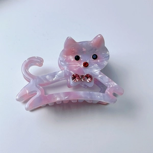 Dettaglio della molletta per capelli a gatto in acetato marmorizzato rosa con strass