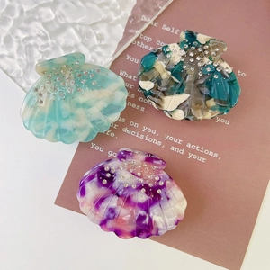 Three-piece shell-shaped acetate hair claws with marble texture and diamond accents