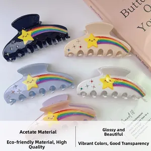 Détail de pinces à cheveux en acétate coloré avec étoiles, strass et rayures arc-en-ciel