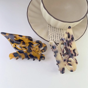 Detail of butterfly hair claws in dark tortoiseshell and marble acetate patterns