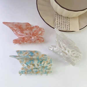 Three elegant acetate butterfly hair claws in marble pink, blue mix, and pearl white colors