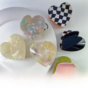 Detail view of heart-shaped acetate hair claws in various checkered and marble patterns
