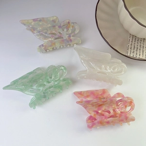 Set of four butterfly acetate hair claws in pastel marble patterns for elegant hair styling