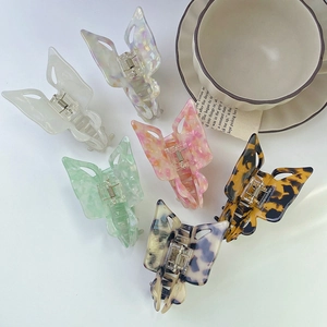 Close-up of butterfly hair claws in acetate finish with marble and leopard textures