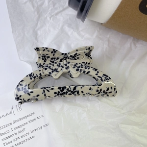 Détail de la pince à cheveux en acétate crème avec motif à pois noirs dalmatien