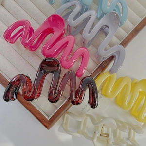 Large wavy hair claw clips in various colors like cream and yellow for thick hair styles