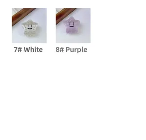 Detail of star-shaped hair claws with smiley face and rhinestones in white and purple