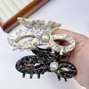 Detailed macro view of black and white marble acetate hair claws with pearls and rhinestones