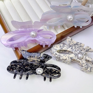 Elegant bow hair claws in lilac and marble patterns with large pearls and sparkling rhinestones