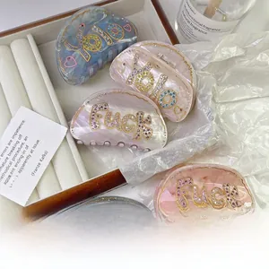 Detail view of acetate claw hair clips with inlaid rhinestones and marble patterns