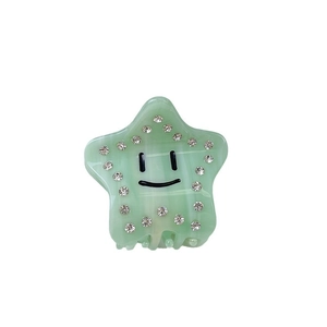 Star-shaped acetate hair claw in light green with smiley face and rhinestone accents