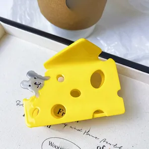 Close-up of cheese shaped hair claw clip with a cute mouse detail on a white tray