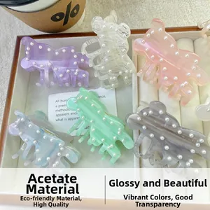 Detailed view of bear-shaped acetate hair claws with pearls in various pastel colors