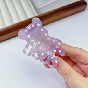 Detail of purple bear hair claw clip with marble acetate finish and small pearls