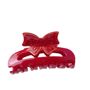 Elegant red acetate bow hair claw clip for women with a glossy finish on white background