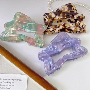 Acetate star hair claws with rhinestones in marble, tortoiseshell, and colorful patterns