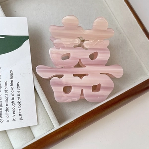 Pink marble texture Chinese Double Happiness hair claw clip on a wooden display tray