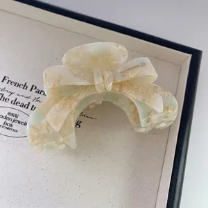 Vue détaillée de la pince à cheveux en acétate vert clair avec motif marbré