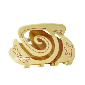 Cream and amber acetate hair claw clip with red heart and star patterns on white background