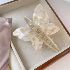 Detail of butterfly hair claw in beige marble acetate with a durable metal spring