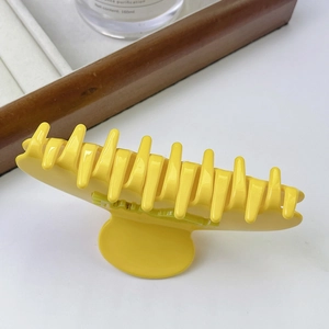 Détail macro d'une pince à cheveux jaune vif en acétate avec inscription en relief