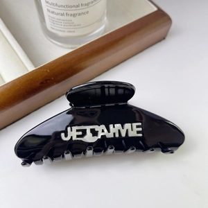 Détail de la pince à cheveux noire en acétate avec inscription blanche JE T'AIME