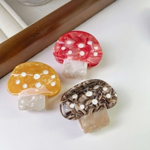Tre fermagli per capelli a fungo in rosso, arancione e marrone con pois bianchi