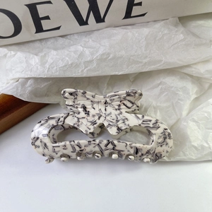 Detailed close-up of marble pattern acetate butterfly hair claw clip with black and white texture