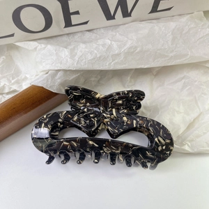 Detailed macro view of an acetate butterfly hair claw with dark tortoiseshell texture