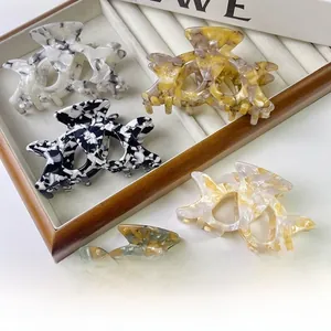 Set of five hollow acetate hair claws with marble and tortoiseshell patterns in a tray