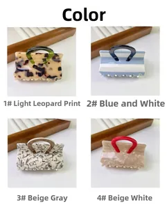 Detail view of four patterned handbag-shaped hair claws in leopard and striped designs