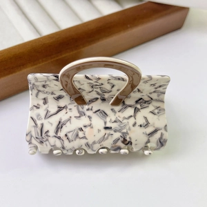 Detail of marble pattern acetate hair claw with brown handle for French hairstyle