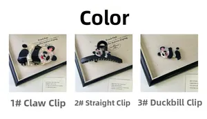 Detailed view of three panda acetate hair clips in a black and white marble finish