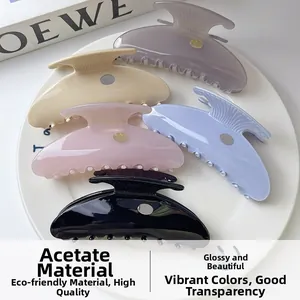 Detail view of five acetate shell hair claws in pastel colors with gold accents