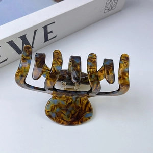 Détail d'une pince à cheveux en acétate avec motif écaille et ressort doré brillant