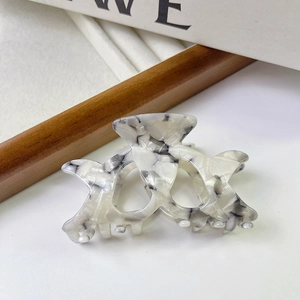Close-up of hollow acetate hair claw with elegant black and white marble texture