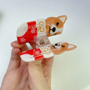 Detail of a Corgi dog hair claw clip with festive red and white snowflake patterns