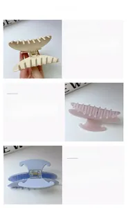 Detailed macro view of scallop and heart acetate hair claws in pink, beige and blue colors