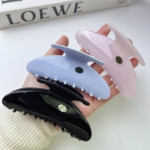 Elegant acetate shell hair claws in black, pink, and glitter blue with gold metal labels
