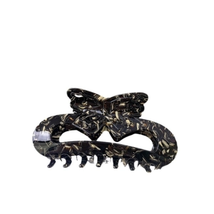 Elegant cutout bow acetate hair claw clip with classic tortoiseshell pattern on white background