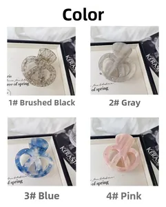 Dettaglio di pinze per capelli in acetato in quattro colori: nero, grigio, blu e rosa