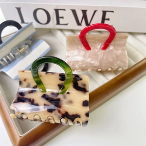 Creative handbag-shaped hair claws in leopard print, pink, and blue stripe patterns