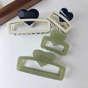 Detailed view of acetic acid hair claws in cream white heart and olive green colors
