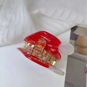 Vue de dessus d'une pince à cheveux bonnet de Noël rouge et blanc avec ressort doré brillant