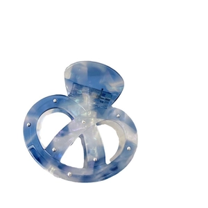 Pinza per capelli in acetato marmorizzato blu con borchie argento e design a nodo ritorto
